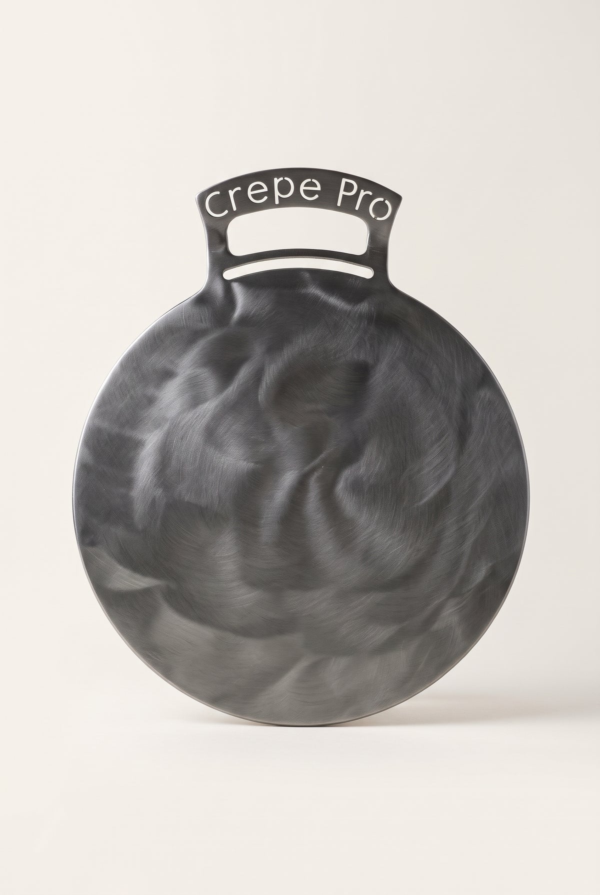 The Crepe Pro 12-inch carbon steel crepe pan with engraved bent handle on a clean studio background