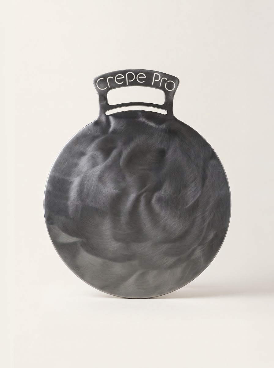 The Crepe Pro 12-inch carbon steel crepe pan with engraved bent handle on a clean studio background
